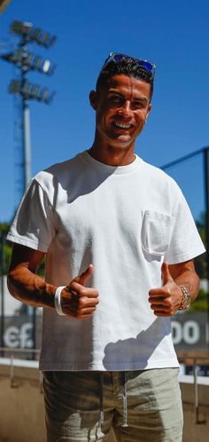 a man in white shirt giving thumbs up