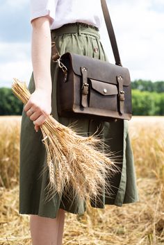 "This leather satchel manifests efficient storage, carrying comfort, and vintage elegance. Just right in size, this versatile leather briefcase holds as much as you need without looking bulky. Small internal and external pockets offer an apt spot for keeping essentials secured and organized. A detachable, adjustable shoulder strap and optional top handle allow you to wear it whichever suits your active lifestyle. Safe, neat belt buckles and patinaed leather bring a final touch of fine vintage.sa Brown Satchel, Leather Satchel Handbags, Model Features, Espresso Brown, Dark Brown Color, Leather Laptop, Leather Messenger Bag, Leather Briefcase, Satchel Purse