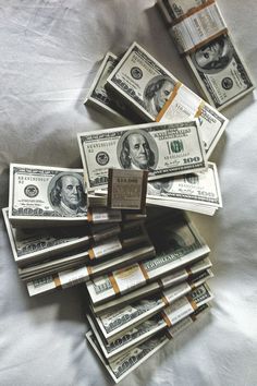 a pile of money sitting on top of a bed