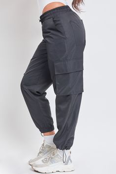 Somedays, getting dressed should just be easy. With a straightforward design, our Women’s High Rise Nylon Cargo Jogger is a true no-fuss pant. These high waisted pants feature an elasticized waistband with an adjustable bungee cord for customizable comfort and fit. They have subtle slant front pockets, side flap cargo pockets, and adjustable bungee hems for a cinched look at the ankle. Pair with a ribbed tank and sneakers for an everyday sporty look, or heels and a bodysuit for something more pl Stringless Jogger Pants Pocket Side, Nylon Long Pants With Functional Drawstring, High Waist Functional Bottoms With Elastic Waistband, Functional Nylon Bottoms With Elastic Waistband, Functional High Waist Bottoms With Elastic Waistband, Functional Full Length Pants With Elastic Waistband, Functional High-waist Bottoms With Elastic Waistband, Outdoor Nylon Bottoms With Elastic Waistband, Nylon Bottoms With Elastic Waistband For Outdoor