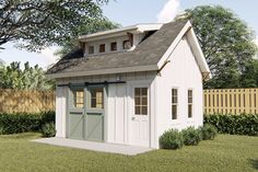 a small white shed sitting on top of a lush green field