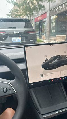 a laptop computer sitting on top of a car dashboard next to a steering wheel and dash