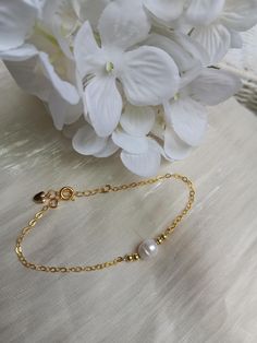 A gorgeous and dainty pearl bracelet.   A classic fresh water pearl sits between tiny gold plated beads, attached to a shiny gold plated over sterling silver (excellent quality) chain. Fits most women's wrist with a length starting at  6.5 and extender going up to 7.5". Dainty Yellow Gold Beaded Bracelets In 14k Gold Filled, Dainty Handmade Gold Beaded Bracelets, Dainty Gold Bracelets With Gold Beads, Dainty Gold Bead Bracelet, Gold Dainty Handmade Chain Bracelet, Dainty Gold Beaded Bracelets, Dainty 14k Gold-filled Beaded Bracelets, Dainty Handmade Gold Chain Bracelet, Minimalist Gold Pearl Bracelet With Delicate Chain