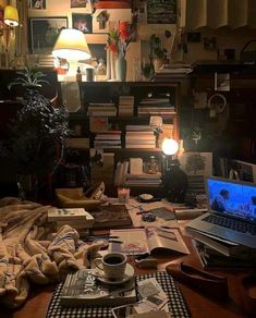 a laptop computer sitting on top of a wooden desk next to a pile of books