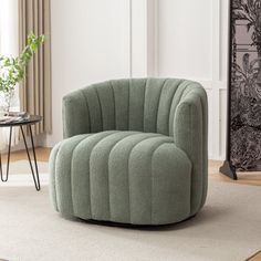 a green chair sitting on top of a rug in front of a white wall and window