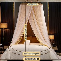 a bed with white drapes and gold trim around it