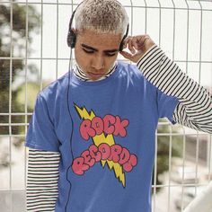 a man wearing headphones and a blue shirt with the word rock'n'roll on it