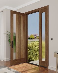 an open wooden door in a white room with wood flooring and large glass doors