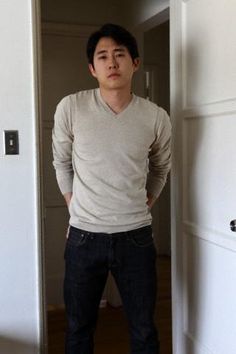 a young man is standing in an open doorway with his hands on his hips and looking at the camera