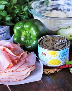 some food is laying out on a wooden table next to green peppers and other ingredients