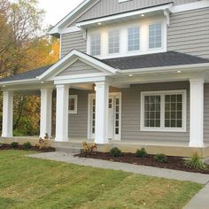 a gray house with white trim and columns