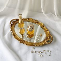 there is a mirror and some jewelry on the bed