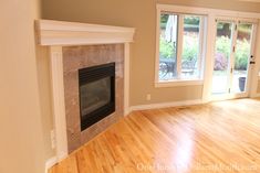 an empty living room with hard wood floors and a fire place in the center area