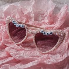 a pair of sunglasses with the word bride written on them, sitting on pink tissue paper