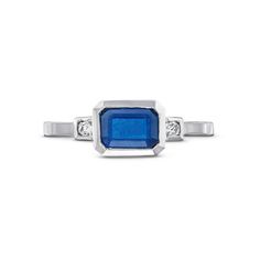 This Emerald Cut Blue Sapphire Diamond Ring features an emerald cut blue sapphire totaling approximately 1.20 carats, accented by brilliant round diamonds on each side. Luxury Square Cut Brilliant Sapphire Ring, Luxury Square-cut Brilliant Sapphire Ring, Square-cut Brilliant Sapphire Ring, Luxury Square-cut Sapphire Ring With Brilliant Cut, Square Cut Brilliant Sapphire Ring, Classic Blue Radiant Cut Sapphire Ring, Blue Sapphire Emerald Cut Promise Ring, Luxury Emerald Cut Sapphire Ring, Modern Emerald Cut Sapphire Ring With Accent Stones