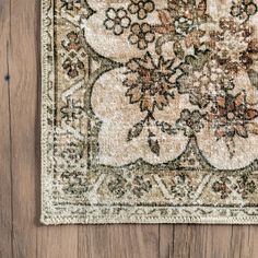 an old rug is laying on the floor next to a wooden wall with wood planks