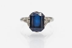 Vintage ring made of 18-carat white gold. Its centerpiece is a faceted, rectangular synthetic sapphire weighing approximately 4.00 carats. Sapphire is distinguished by its beautiful, deep blue color. Synthetic sapphire means that it was created by humans in laboratory conditions and has the same chemical and physical properties as natural sapphire. The synthesis of sapphires began at the beginning of the 20th century and became very popular. Origin: France, second half of the 20th century. Prese Octagon Brilliant Cut Sapphire Ring For Formal Events, Classic Octagon Sapphire Ring For Anniversary, Formal Octagon Brilliant Cut Sapphire Ring, Formal Octagon Sapphire Ring With Brilliant Cut, Classic White Gold Sapphire Ring With Baguette Cut, Classic Octagon Sapphire Ring With Diamond, Formal Sterling Silver Rectangular Diamond Ring, Formal Octagon Sapphire Ring With Diamond Cut, Formal Sapphire Ring With Octagon Diamond Cut