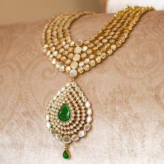 An heirloom of divinity, crafted through the ages! Introducing an opulent fiver-layer kundan mala, adorned with a magnificent emerald stone centerpiece that exudes timeless elegance, this set blends the regal charm of kundan with the vibrant allure of emeralds. A masterpiece of craftsmanship, it promises to elevate any occasion with its majestic allure. The listing includes long mala and a pair of matching earrings. Gold-plated on high-quality brass as base metal. Made by order. Kindly allow 5-7 Elegant Kundan Temple Necklace For Puja, Emerald Kundan Necklace With Intricate Design For Festive Occasions, Elegant Kundan Necklace With Meenakari For Puja, Festive Emerald Kundan Necklace With Intricate Design, Green Jewelry With Intricate Design For Puja, Green Intricate Design Jewelry For Puja, Green Intricate Jewelry For Puja, Gold Kundan Mala For Rituals, Festive Emerald Kundan Chandbali Necklace