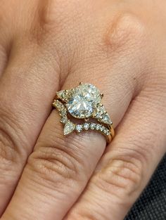 a woman's hand with a diamond ring on top of her finger and an engagement band