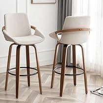 two white bar stools sitting next to each other on top of a wooden floor