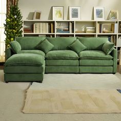 a green couch sitting in front of a book shelf