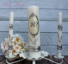 three white candles sitting on top of a table