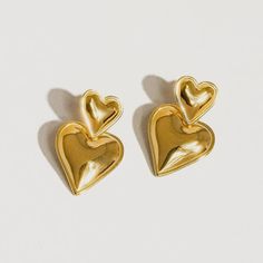 These layered hear earrings make heart earrings modern. This pairing of gold drop earrings features a simple stud connected to an elegant gold heart drop. We love this style for date night, girls' night, or really any night, as a matter of fact. 18k gold plated stainless steel Measurement (L x W inch): 1.2 x 0.8 Post back closure Tarnish free Style For Date, Elegant Gold Heart Earrings In Brass, Gold Brass Heart Earrings With Pierced Details, Brass Heart Drop Earrings, Tarnish-resistant Yellow Gold Heart Earrings, Retro Gold Heart-shaped Earrings, Cardigan Sweater Dress, Plus Size Shopping, Gold Drop Earrings