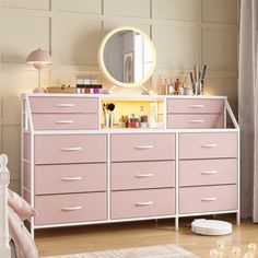 there is a pink dresser with many drawers in the room and a mirror above it