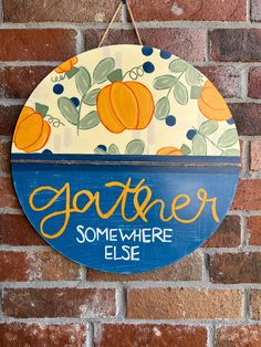 a sign hanging on the side of a brick wall that says, gather somewhere else