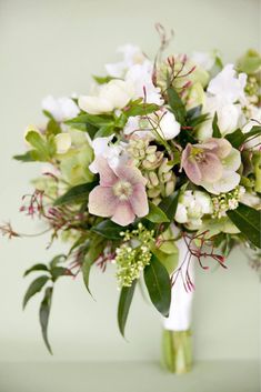 a bridal bouquet with white and pink flowers on green stems, greenery and leaves