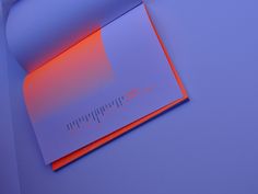 an orange and blue piece of paper sitting on top of a purple surface with lines drawn across it