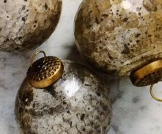 three decorative vases sitting on top of a marble countertop next to each other