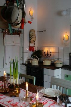 a kitchen with candles and dishes on the table