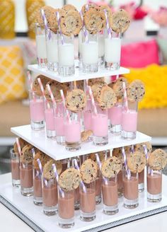 a table topped with lots of pink and gold desserts next to balloon filled wall