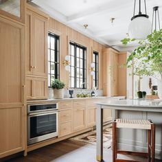 a kitchen with wooden cabinets and an island in front of the stove top oven is shown