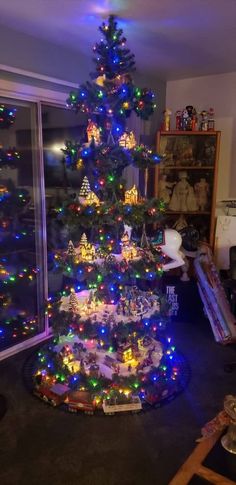 a brightly lit christmas tree in a living room