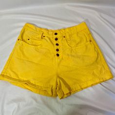 Vintage 90's LEI high waisted yellow denim shorts. The shorts are 100% cotton. They have a button fly with LEI logo buttons and gold hardware.  The shorts are in fair condition. There is a light orange spot on the front and the fly buttons have bled rust color. I am pricing super cheap due to these issues.  Size Large Measurements  Waist- 35 inches  Hip- 22 inches  Length- 16 inches Cheap Casual Yellow Jean Shorts, Cheap Yellow Shorts With Pockets, Yellow Jean Shorts, Cheap Yellow Jean Shorts, High-rise Buttoned Shorts For Summer, Summer Jean Shorts With Buttons, Jean Shorts With Buttons For Summer, High-waisted Button Jean Shorts For Summer, High-waisted Cotton Shorts With Buttons