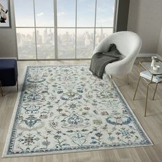 a living room with a large rug on the floor next to a chair and table