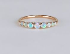 a gold ring with opal stones on the side and three smaller opals in the middle