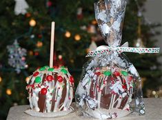 two chocolate covered desserts sitting on top of a table next to a christmas tree