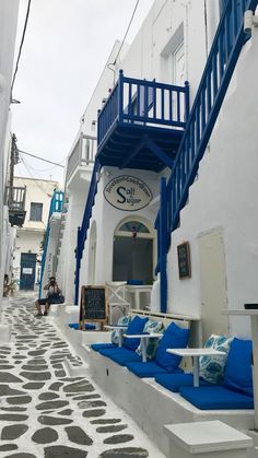 an alley way with white and blue buildings