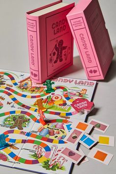 a pink book and matching game pieces on a white surface with other games in the background