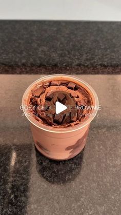 a plastic container filled with chocolate chips on top of a counter next to a black counter