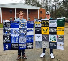 two boys holding up their college banners in front of a building