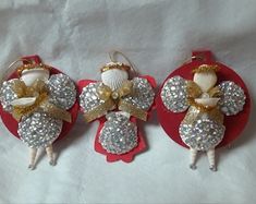 three red and white christmas ornaments with gold bows on them are sitting on a table