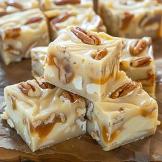 several pieces of white chocolate with pecans on top and caramel in the middle