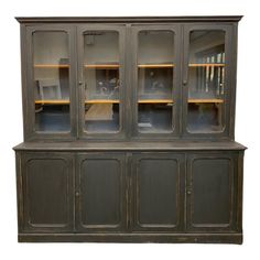 an old china cabinet with glass doors and shelves on the front, against a white background