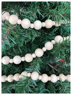 a close up of a christmas tree with balls hanging from it's branches and pine cones