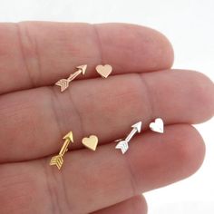 A sweet and simple pair of Heart & Arrow mismatched stud earrings in sterling silver.Earrings are made of 925 silverThe gold earrings are 14k gold plated over sterling silver (gold vermeil).The earrings measureHeart- 4mmArrow- 3mm x 10mmGreat for those with sensitive ears.Mix and match with my other stud earringsIncludes sterling silver earring backs.This listing is for ONE PAIR (2 pieces). Tiny Gold Necklace, Gold Knot Earrings, Sterling Silver Heart Earrings, Dainty Gold Earrings, Gold Heart Studs, Chevron Earrings, Arrow Earrings, Silver Heart Earrings, Earrings Heart