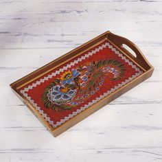 a red and gold tray with a dragon design on the front is sitting on a white wooden surface